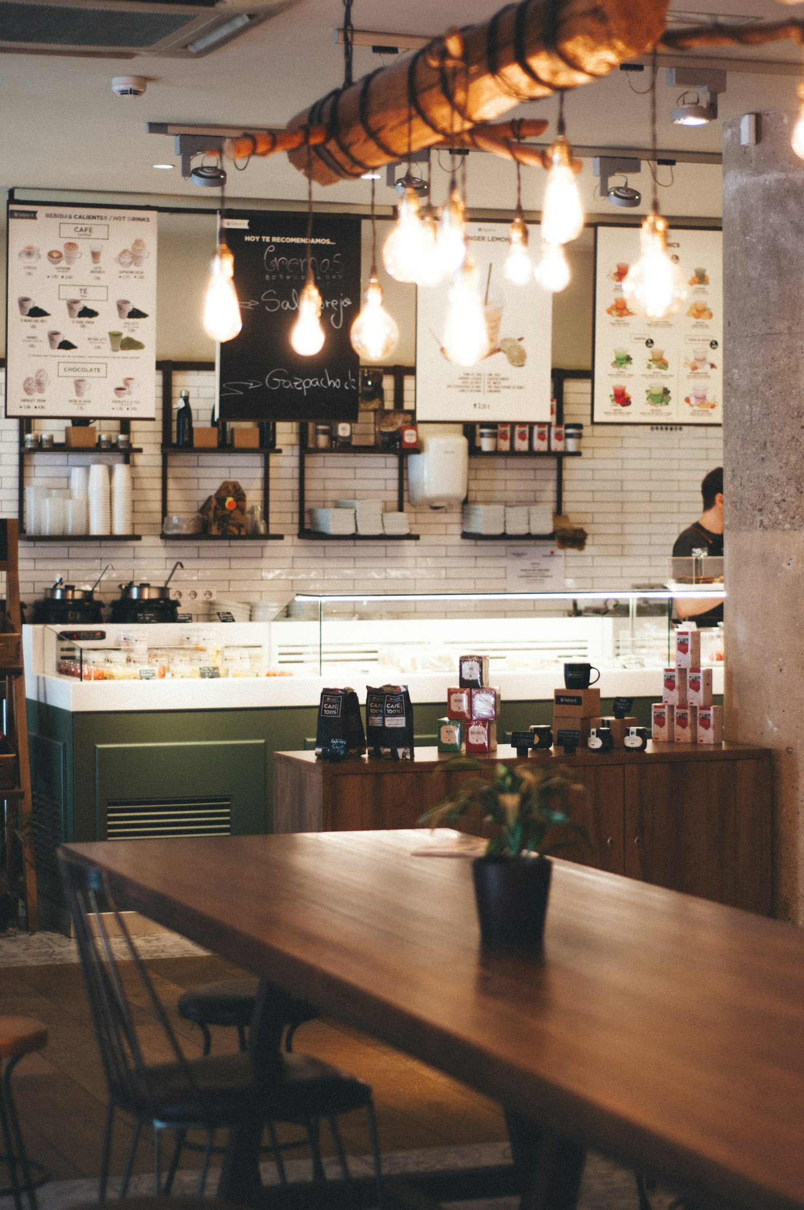 Cafe counter with display case and communal wood table