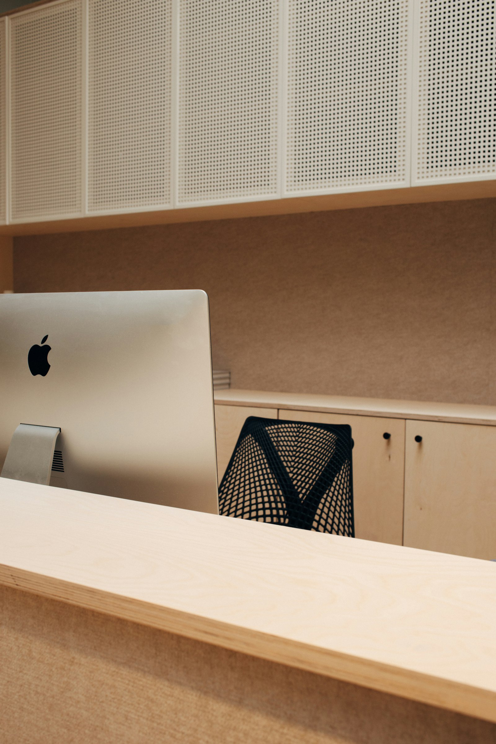 Office reception desk with perforated wall cabinets