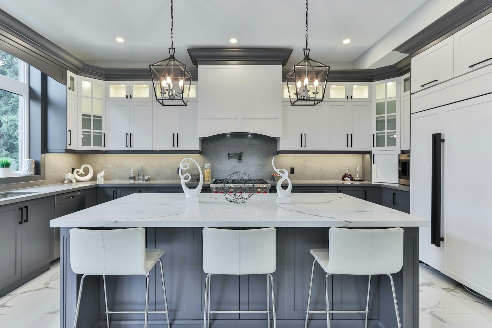 Gray and white kitchen with lantern pendants and crown molding