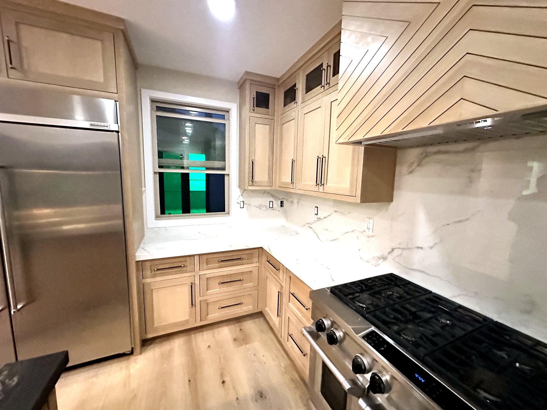 Rift-sawn oak cabinetry with marble slab backsplash