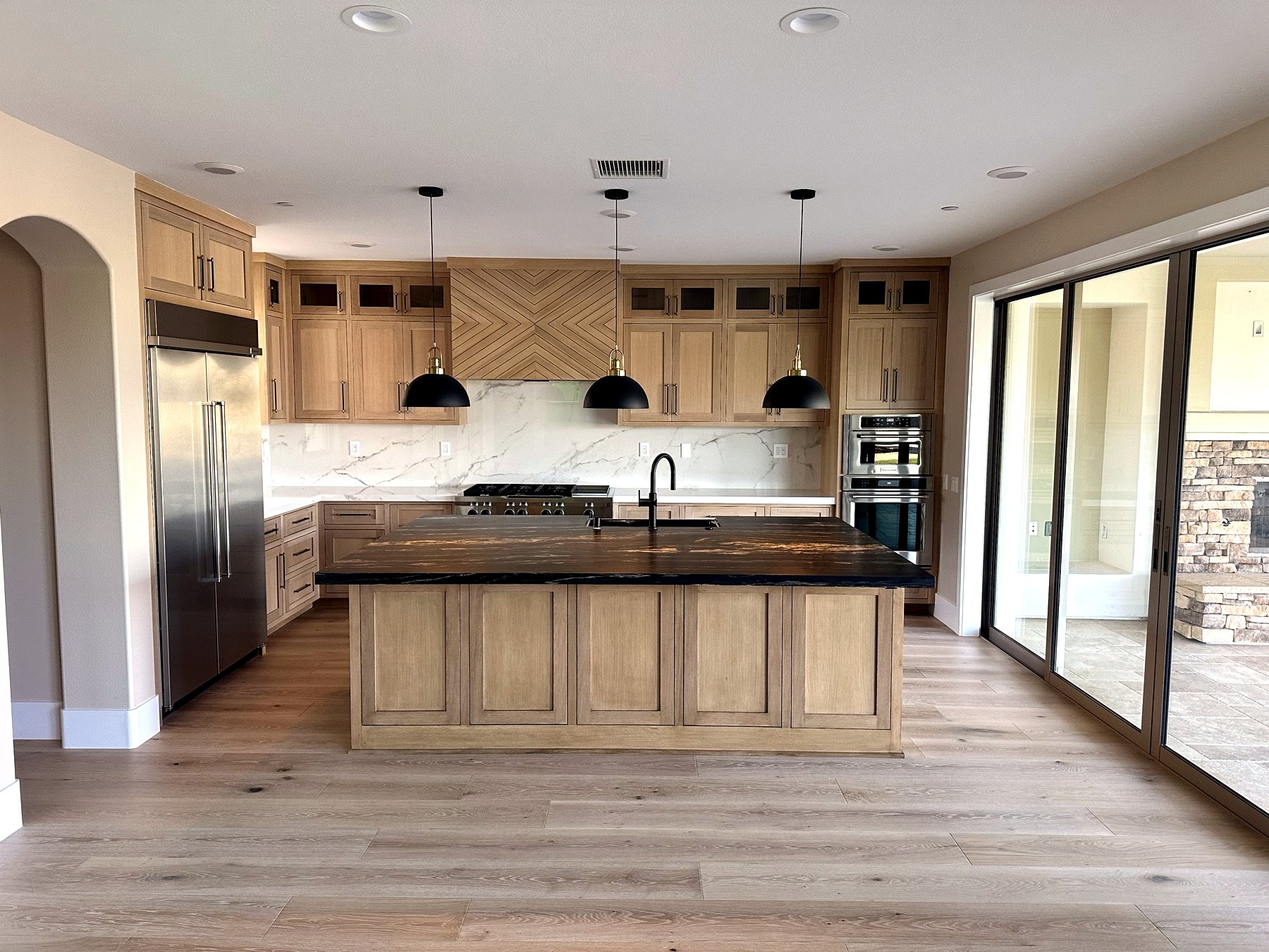 White oak custom kitchen with dark island and custom hood