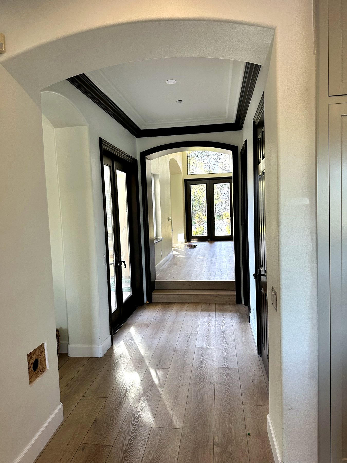Hallway with dramatic dark-stained trim and casing